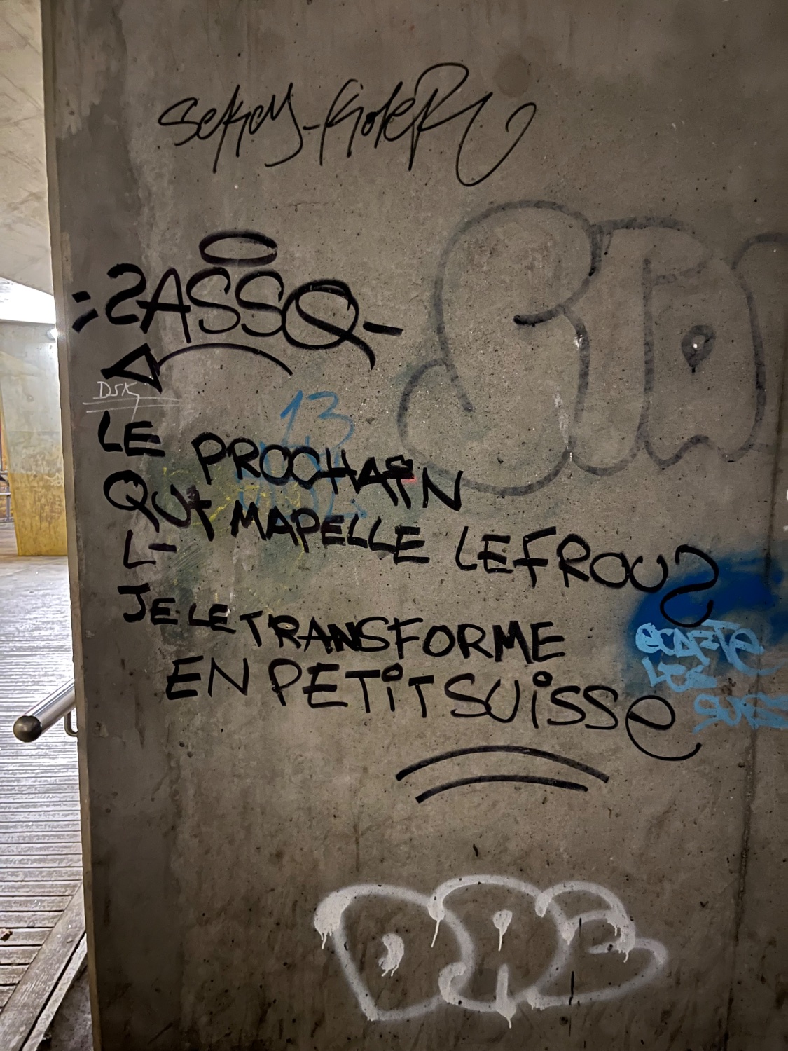 Un tag sur un mur qui dit "Le prochain qui m’appelle le frouze, je le transforme en petit Suisse"