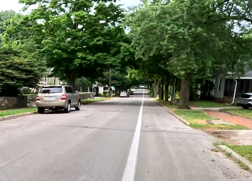 View of Washington Street south of 1st. There is a parked car on the left and a painted bike lane on the right.