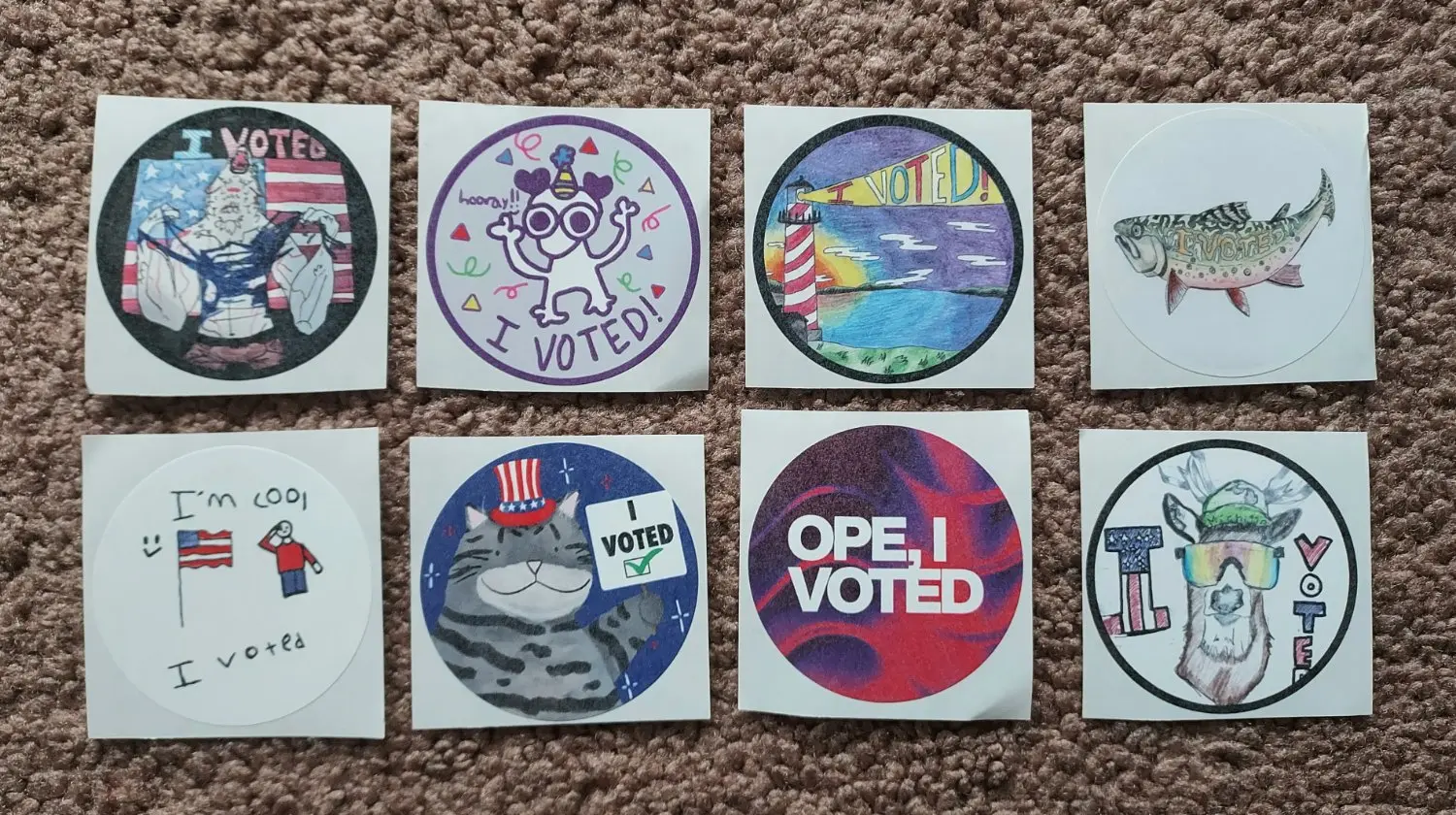 "I Voted" stickers: werewolf, party creature, lighthouse, fish, flag salute, cat, "OPE", and deer with cool glasses.