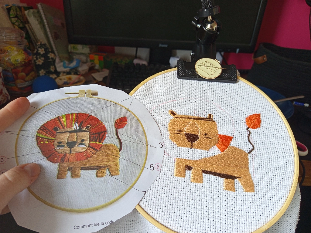 broderie en cours avec son modèle. Un lion enfantin déguisé en indien.